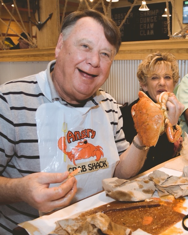 A couple holding up crab at the table