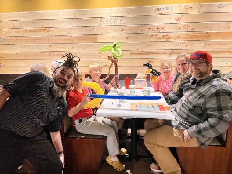 Guests at a booth with a balloon animal