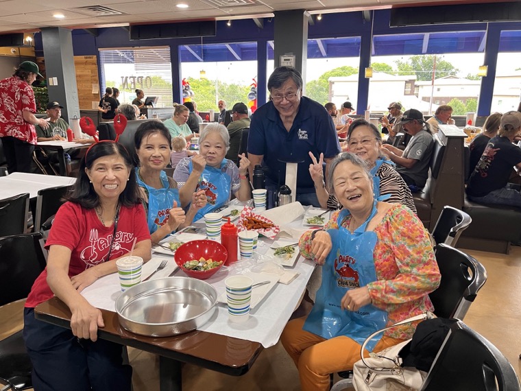 A large family group smiling at a table in bibs