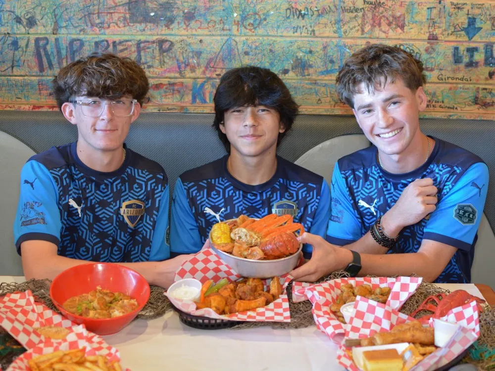 Three FC Arizona players sharing a seafood boil at the shack